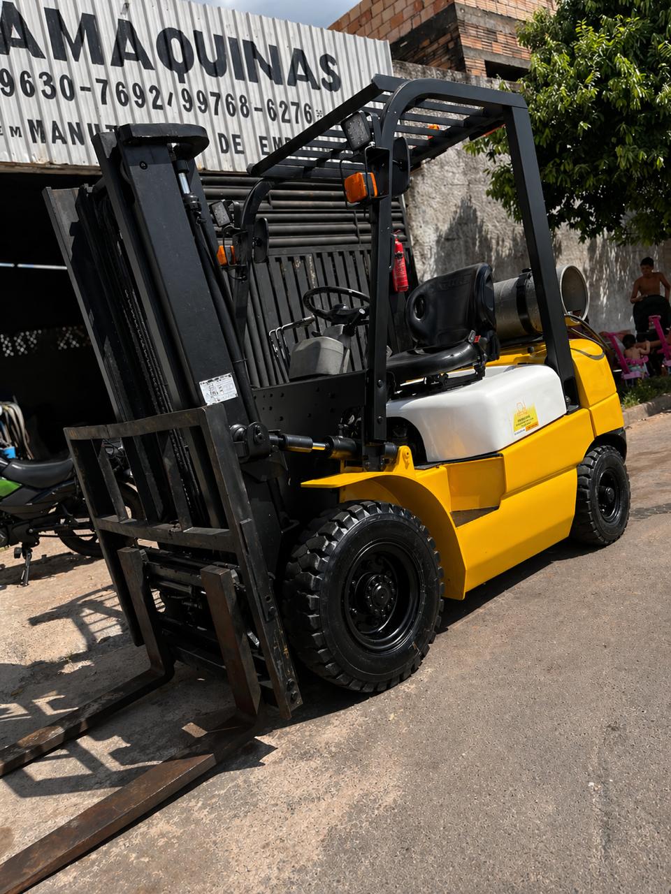 Empilhadeira amarela estacionada na oficina da Framáquinas