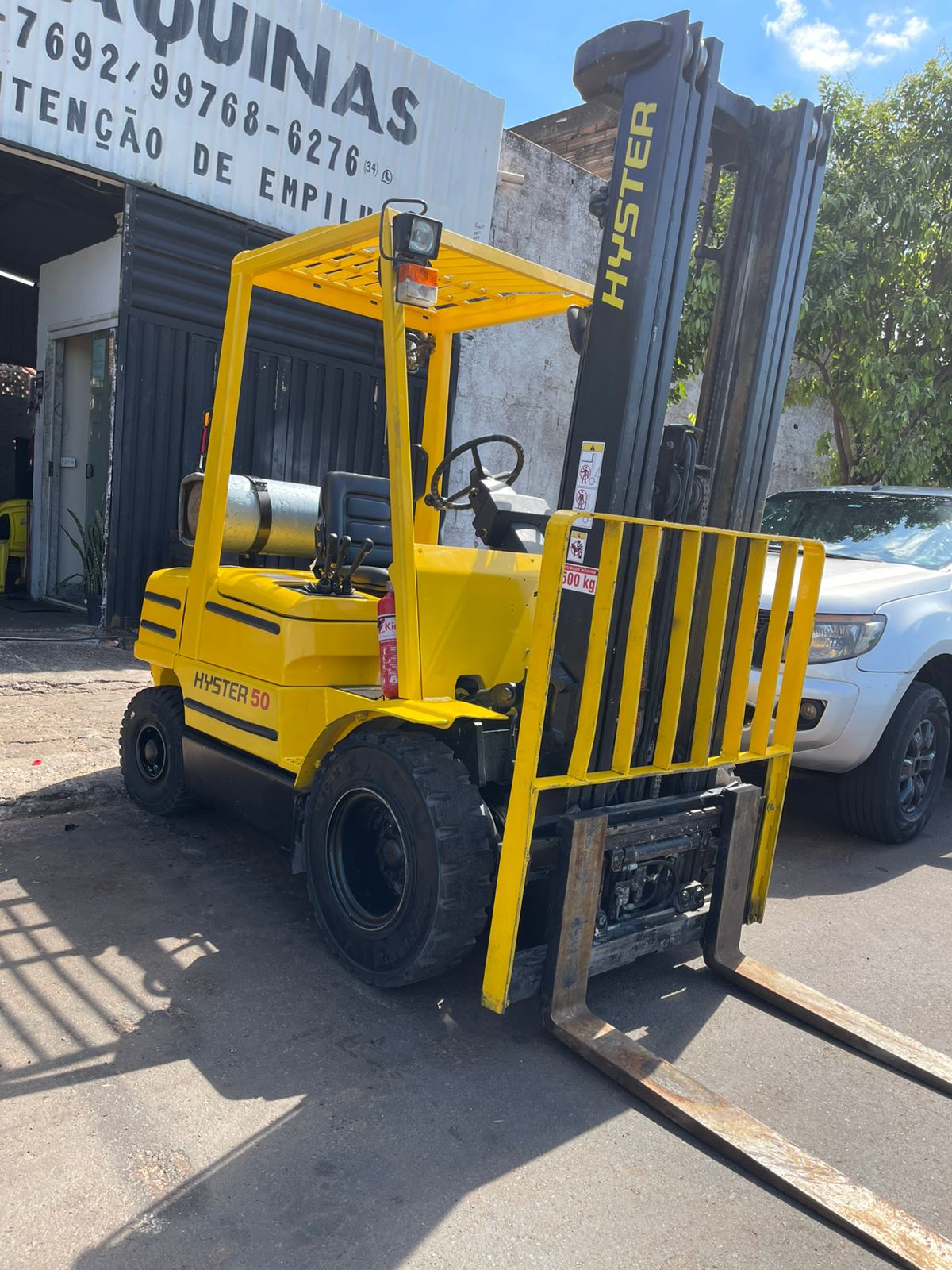 Empilhadeira Hyster 50 amarela em frente à oficina da Framáquinas